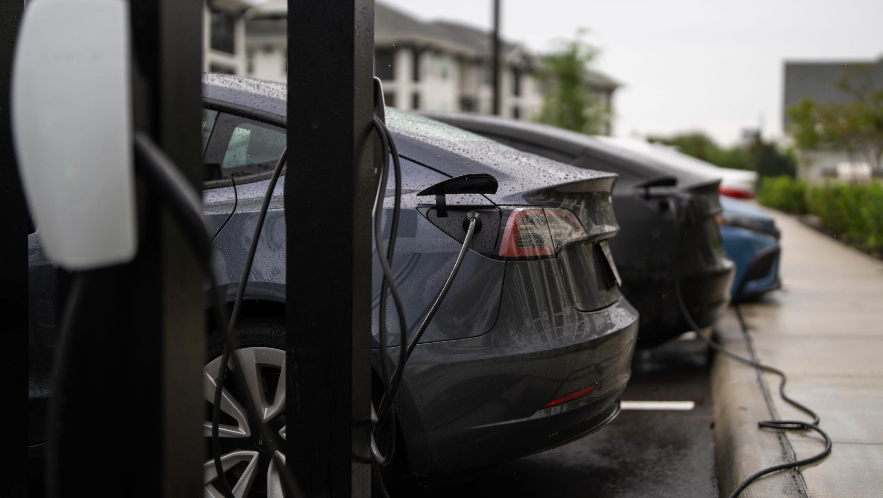 Biler lader på parkeringsplass med ladestasjoner
